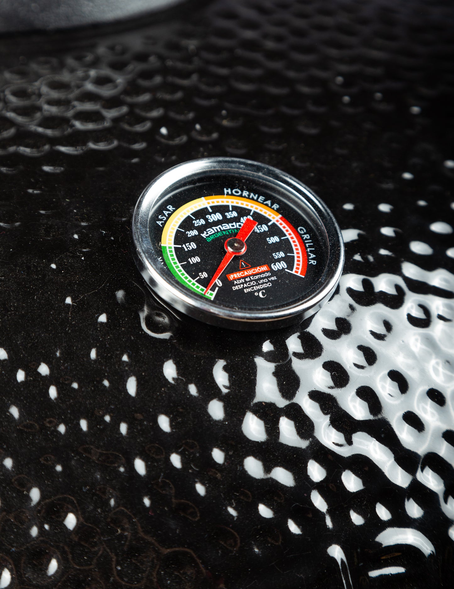 Closeup of the Kamado Argentino Big Gaucho Grill Black showcasing the front thermometer.